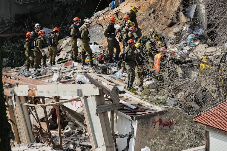 Israeli rescue teams search for missing people amid the rubble of a residential building a day after it was struck by an Iranian missile in Haifa, Israel, Monday, April 6, 2026.