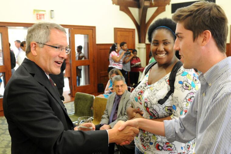 Neil Theobald, senior VP and chief financial officer at Indianna University, shook hands with Temple junior Robert Scanlon, Williow Grove, as senior Shanee Satchell, Laurel, MD, looked on inside Shusterman Hall. ( CLEM MURRAY / Staff Photographer )