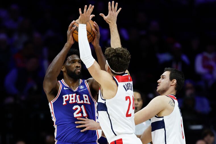 Sixers center Joel Embiid looks to pass against the Wizards' Corey Kispert (center) and Danilo Gallinari during the first quarter on Monday.