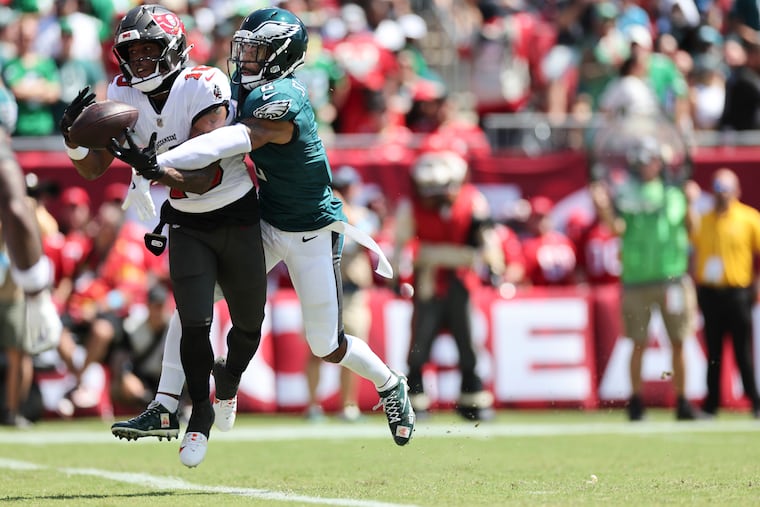 Buccaneers wide receiver Trey Palmer scores a first-quarter touchdown despite the efforts of cornerback Darius Slay.