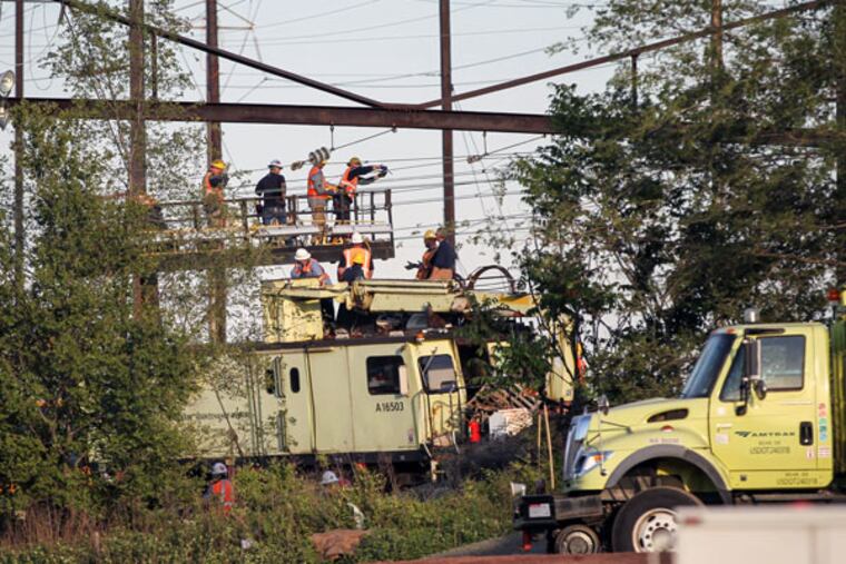Workers repair Catenary wires at the scene of the crash. (STEVEN M. FALK / STAFF PHOTOGRAPHER)