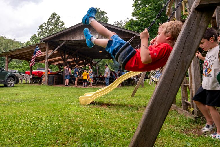 Liam Way (left) and Daniel Kieser (right, both five years old) play on the swing while the grownups gather during a family reunion in Forksville June 23, 2024. 