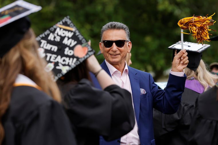 Rowan University President Ali A. Houshmand waves a pom pom as graduates of the College of Education exit the graduation ceremony at Rowan University in Glassboro, N.J. on May 12, 2022.