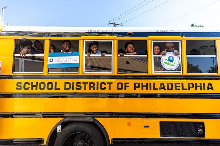 Students at Robert E. Lamberton Elementary School look out the windows of an electric bus. The Philadelphia School District has been awarded $17 million in grants to buy 45 new electric school buses.