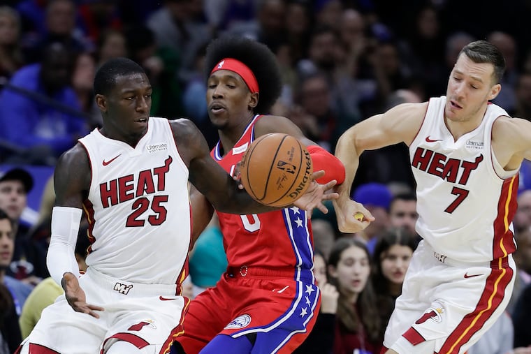 Sixers guard Josh Richardson attempts the steal the basketball against Miami Heat guard Kendrick Nunn and past Miami Heat guard Goran Dragic (right) during the first-quarter on Saturday, November 23, 2019 in Philadelphia. Richardson fouled Nunn on the play.