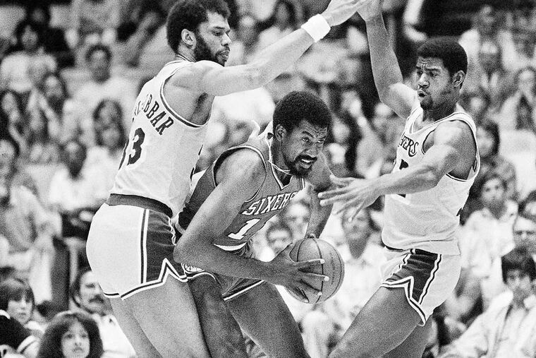Los Angeles Lakers center Kareem Abdul-Jabbar, left and guard Earvin "Magic" Johnson appear to form a bridge while covering Philadelphia 76ers forward Caldwell Jones, center, in the first period of their NBA World Championship game in Los Angeles, May 4, 1980. (AP Photo/Randy Rasmussen)