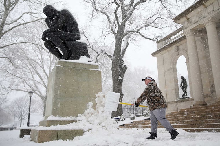 Katie Rumsey shovels snow next to the "Thinker" statue in front of the Rodin Museum on Wednesday, March 21, 2018. It was the fourth nor'easter in March.