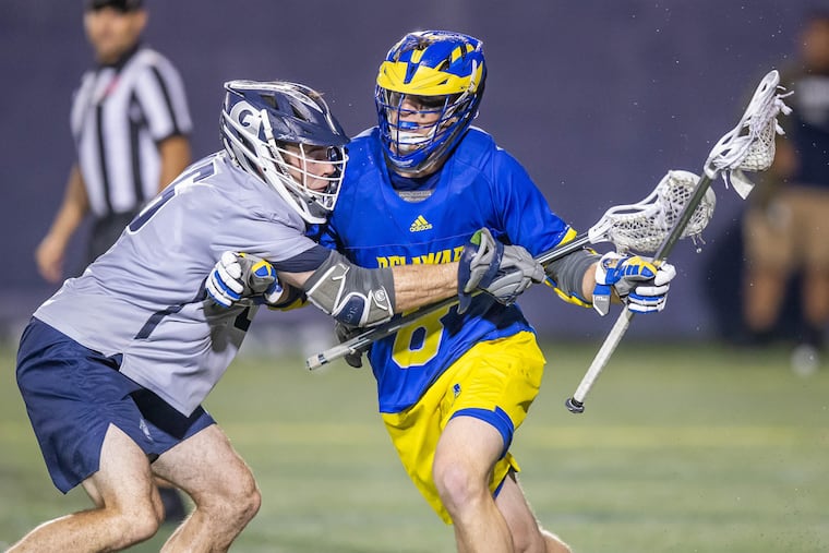 Drew Lenkaitis of Delaware holds off a Georgetown defender.