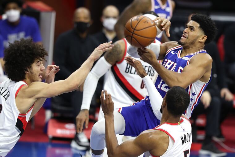 Tobias Harris (right) of the SIxers loses the ball as he goes up for a shot against the Trail Blazers during the first half.