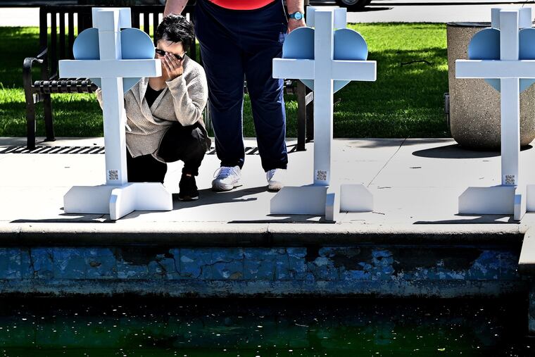 A Robb Elementary school employee named Amy visits a memorial for the victims of a mass shooting in Uvalde, Texas, on Thursday, May 26, 2022. Nineteen students and two teachers died when a gunman opened fire in a classroom Tuesday.