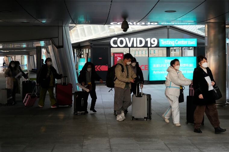 Passengers arriving from China pass by a COVID-19 testing center at the Incheon International Airport In Incheon, South Korea, Tuesday, Jan. 10, 2023. Chinese embassies stopped issuing new visas for South Koreans and Japanese on Tuesday.