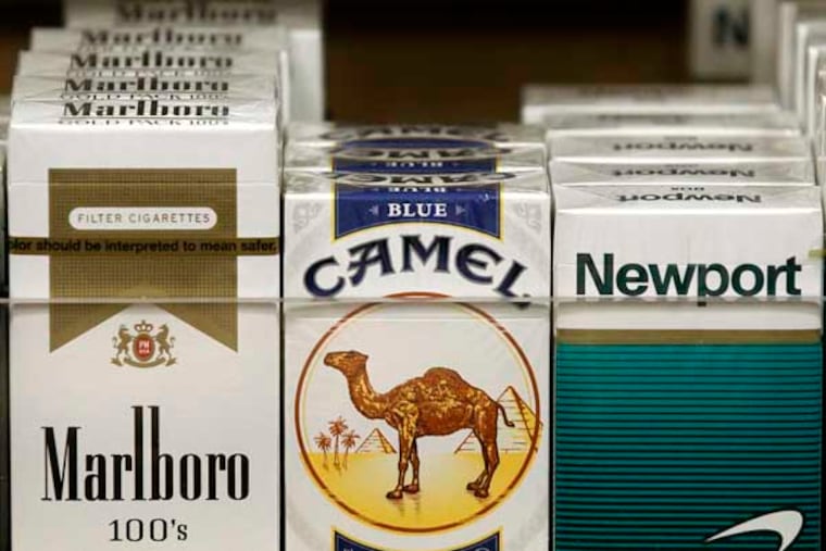Pictured are packs of cigarettes waiting to be purchased at a news stand Friday, Nov. 30, 2012. (AP Photo/Charles Rex Arbogast)