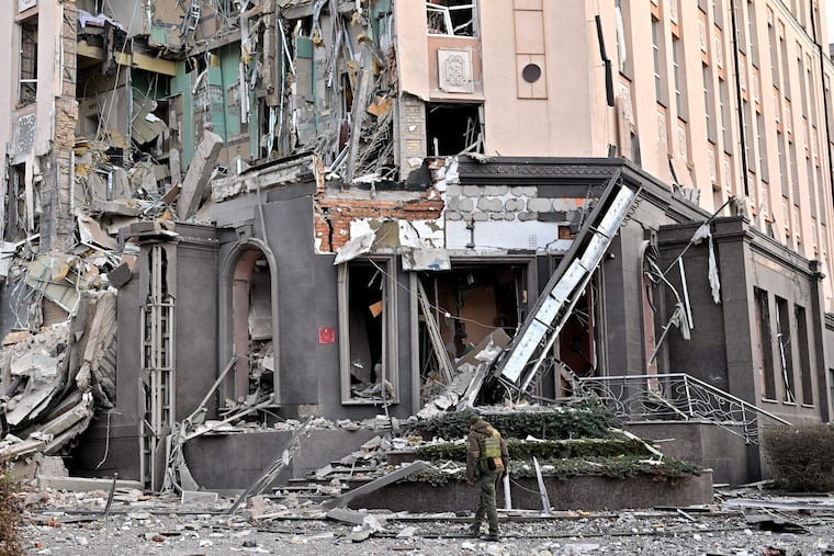 A serviceman walks at the bottom of a hotel, which has been partially destroyed by a Russian strike in the center of Kyiv, on Saturday.