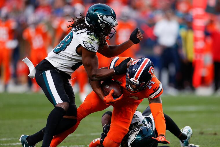 Eagles safeties Anthony Harris (left) and Rodney McLeod stopping Denver Broncos wide receiver Courtland Sutton on Nov. 14, 2021 in Denver.