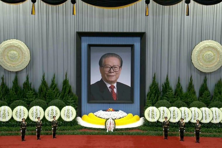 In this image taken from video footage run by China's CCTV, honor guard members stood near a giant portrait of late former Chinese President Jiang Zemin during a formal memorial held at the Great Hall of the People in Beijing on Dec. 6.