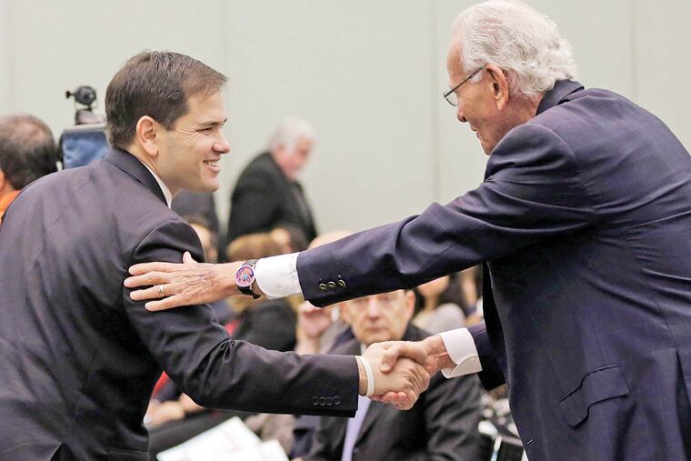 Sen. Marco Rubio (left) shakes hands with Norman Braman, a supporter of his presidential campaign. (LYNNE SLADKY / ASSOCIATED PRESS)