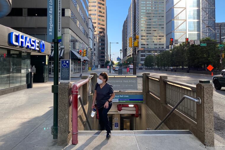 A lone pedestrian exits the from underground at JFK and 17th Street in Center City. SEPTA Regional Rail trains from the suburbs arrive at Suburban Station.