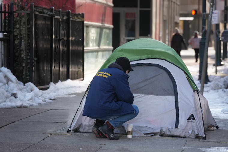 Outreach worker Tim Neumann checks on people experiencing housing instability amid a historic cold snap in Philadelphia on Friday.