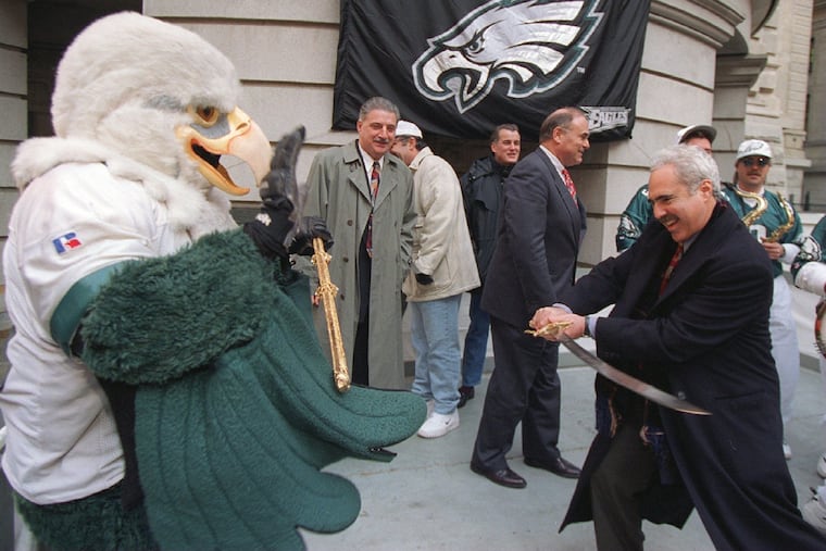 Eagles owner Jeffery Lurie pretends to duel with Eagles mascot Swoop at a rally in the city hall courtyard on Dec. 24, 1996.