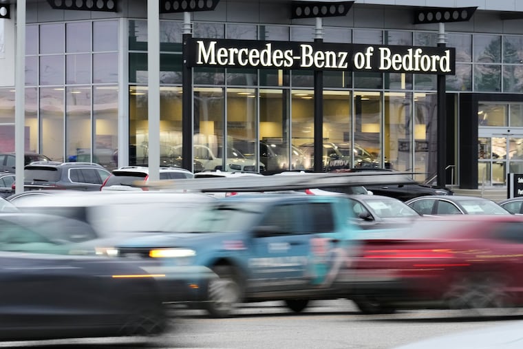 Cars drive by a Mercedes-Benz dealership on the Bedford Automile in Bedford, Ohio, on Feb. 20.