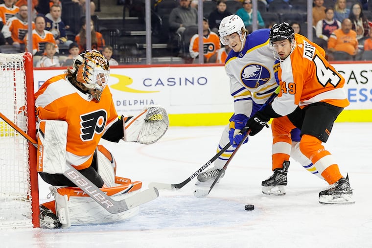 Flyers goaltender Felix Sandstrom watches the puck as Noah Cates (49) defends Buffalo Sabres right wing Tage Thompson in April.