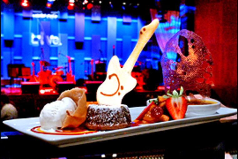 The desserts from Michael Vandergeest, including a brownie sundae, lemon cheesecake, and warm apple cobbler, are whimsically garnished with chocolates and guitar-shaped cookies. (John Costello/Inquirer)