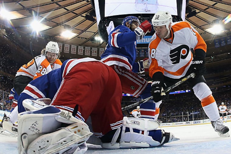 Claude Giroux #28 and Adam Hall #18 of the Philadelphia Flyers attack the net as Henrik Lundqvist #30 of the New York Rangers attempts to cover the puck during the first period in Game One of the First Round of the 2014 NHL Stanley Cup Playoffs at Madison Square Garden on April 17, 2014 in New York City. (Photo by Bruce Bennett/Getty Images)
