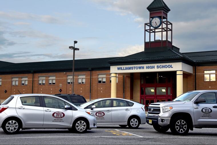 Vehicles from an environmental remediation company in front of Williamstown High School.