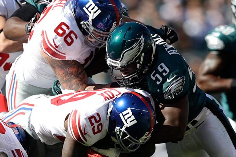 Eagles linebacker DeMeco Ryans tackles Giants running back Michael Cox during the first half. (Matt Rourke/AP)