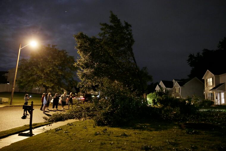 Neighbors gather around Sue Murray’s Valley Green Road home in Deptford, where winds toppled half of her pear tree into the family's Ford Escape during a fast-moving storm that blew through South Jersey on Thursday evening. A tornado was confirmed in Mullica Hill.