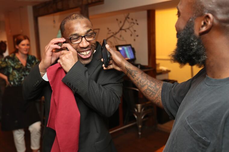 Anthony Wright, left, received many congratulatory phone calls during the celebration at Nomad Pizza just hours after being released on Tuesday August 23, 2016. Wright is the Philadelphia man who served nearly 25 years of a life-without-parole sentence for a 1991 rape and murder that DNA evidence decades later proved he did not commit.