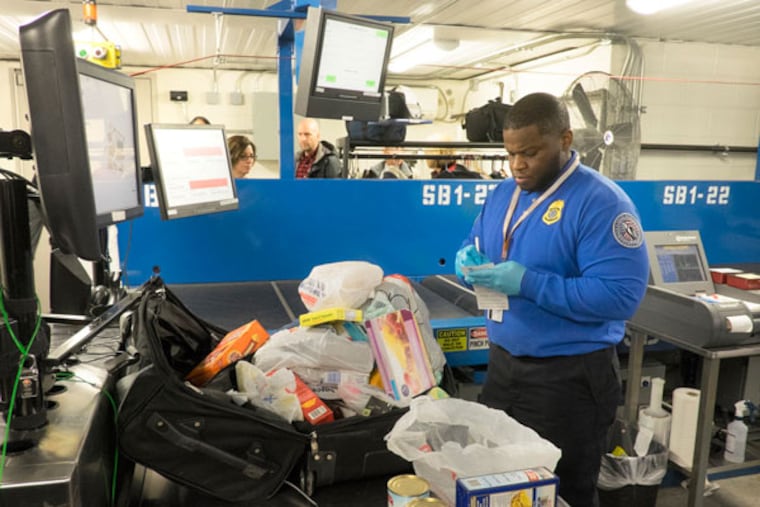 Lead security officer Jonathan Emory checks a bag that was tagged as suspicious by the screening machine in the Checked Baggage Reconciliation Room. ( ED HILLE / Staff Photographer )