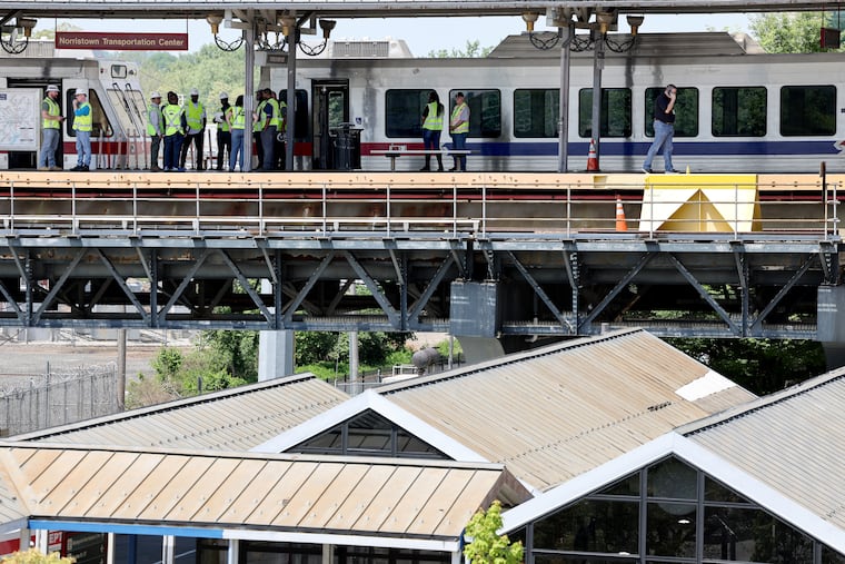 SEPTA employees gathered on an elevated platform after a train crash at the Norristown Transportation Center injured eight people in Norristown on Sunday morning.
