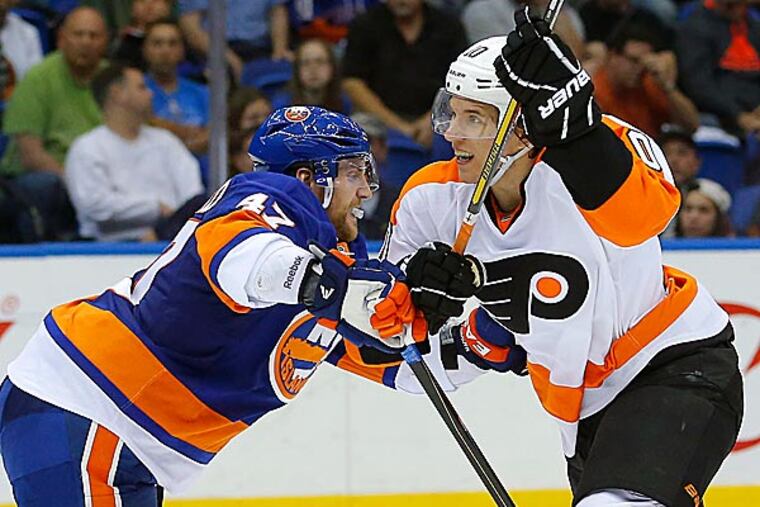 Islanders defenseman Andrew MacDonald checks Flyers center Brayden Schenn. (Paul J. Bereswill/AP)