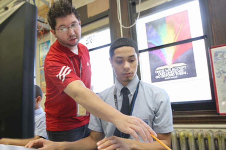 Manuel Rosado and teacher Eric Cruz go over an assignment. "Manuel is the epitome of resilience,"a school social worker says. (Michael Bryant / Staff Photographer)