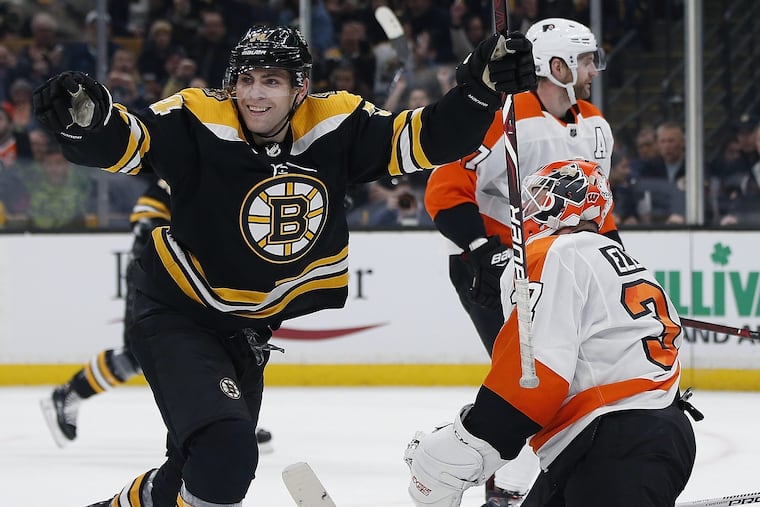 Boston's Jake DeBrusk (74) celebrates his power-play goal against Flyers goalie Brian Elliott during the second period Thursday.