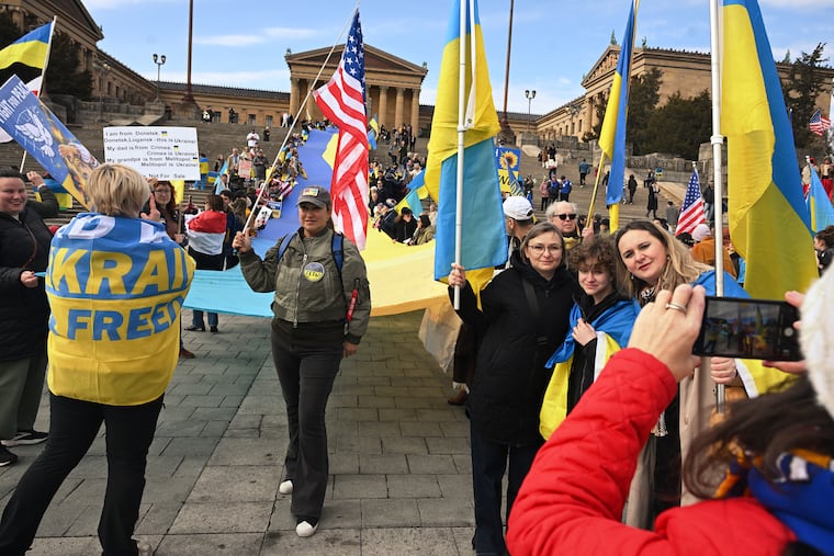 People gather on the Art Museum steps Sunday, standing with Ukraine at a snowstorm-delayed rally marking the fourth anniversary of the Russian war on Ukraine.