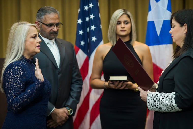 Justice Secretary Wanda Vazquez is sworn in as governor of Puerto Rico by Supreme Court Justice Maite Oronoz, in San Juan, Puerto Rico, Wednesday, Aug. 7, 2019. Vazquez took the oath of office early Wednesday evening at the Puerto Rican Supreme Court, which earlier in the day ruled that Pedro Pierluisi's swearing in last week was unconstitutional. Vazquez was joined by her daughter Beatriz Diaz Vazquez and her husband Judge Jorge Diaz.