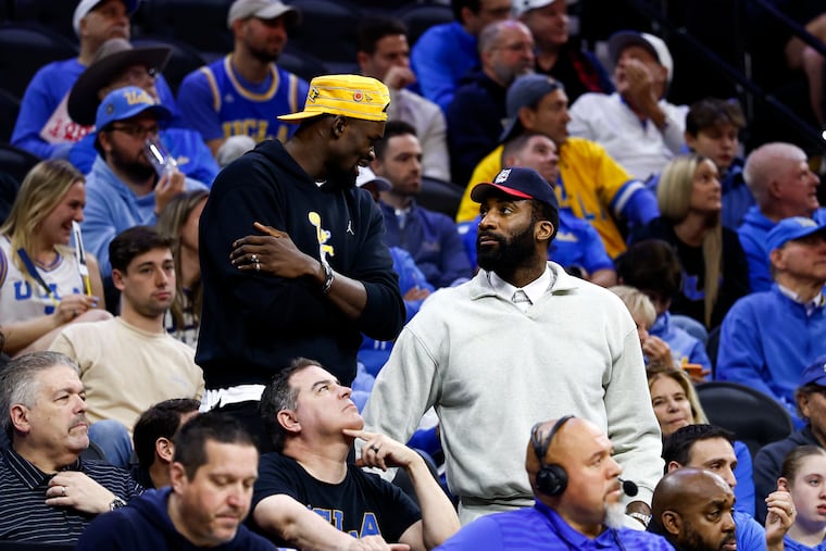 The Sixers' Adem Bona (left) and Andre Drummond talk during the UCLA-UConn game in the second round of the NCAA Tournament on Sunday at Xfinity Mobile Arena.