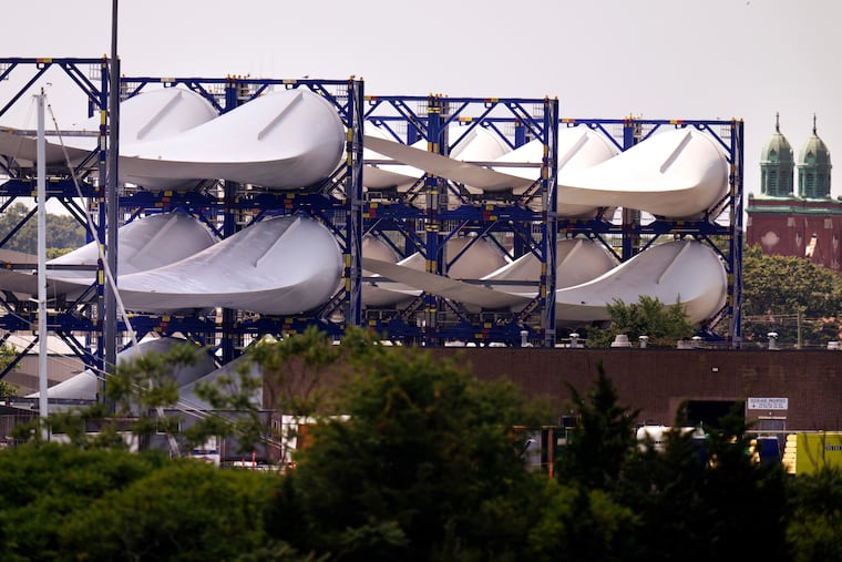 Giant wind turbine blades for the Vineyard Winds project are stacked on racks in the harbor, July 11, 2023, in New Bedford, Mass.