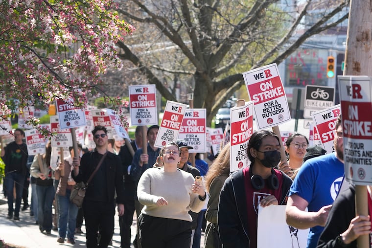 Strikers march in front of Rutgers' buildings in New Brunswick, N.J., Monday, April 10, 2023.
