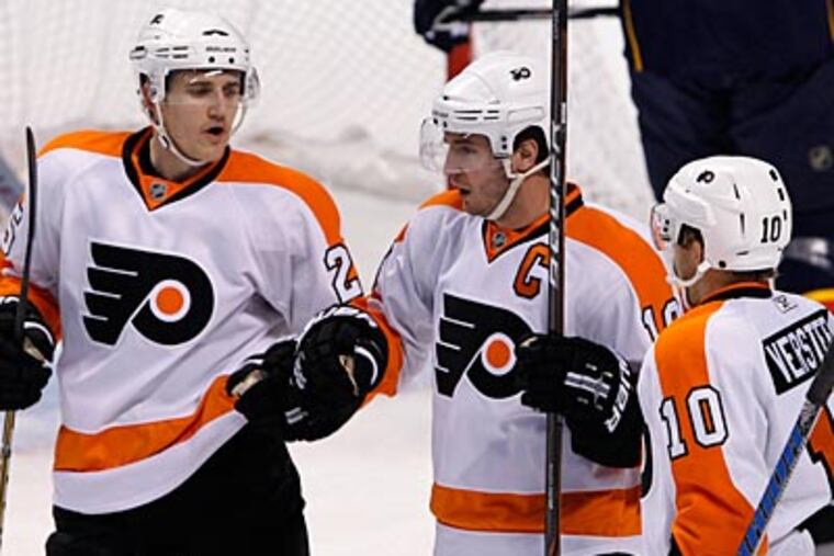 Mike Richards, center, celebrates his first period goal with Kris Versteeg, right, and Matt Carle. (Wilfredo Lee/AP Photo)