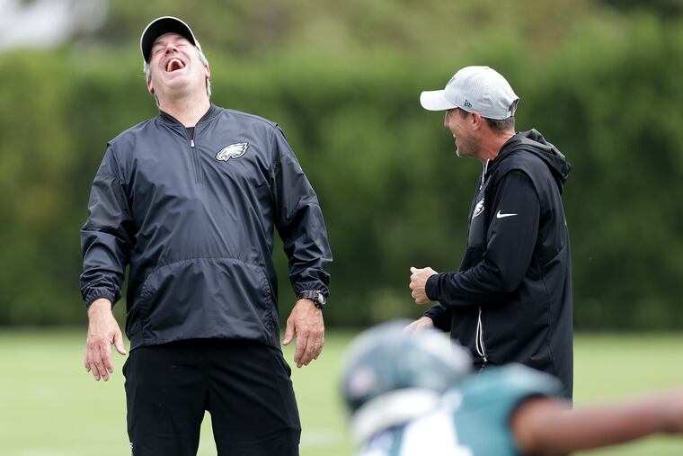 Eagles' head coach Doug Pederson, left, laughs with special teams coordinator Dave Fipp during the Philadelphia Eagles practice in Philadelphia, PA on September 12, 2018. The team is preparing for the Tampa Bay Buccaneers on Sunday. DAVID MAIALETTI / Staff Photographer