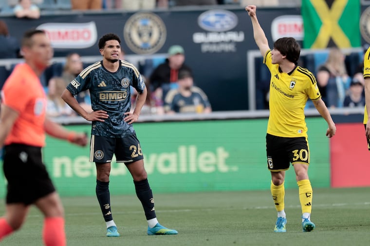 Union defender Nathan Harriel (left) looks on after Columbus' Hugo Picard celebrates after his goal in the 10th minute for the Crew.