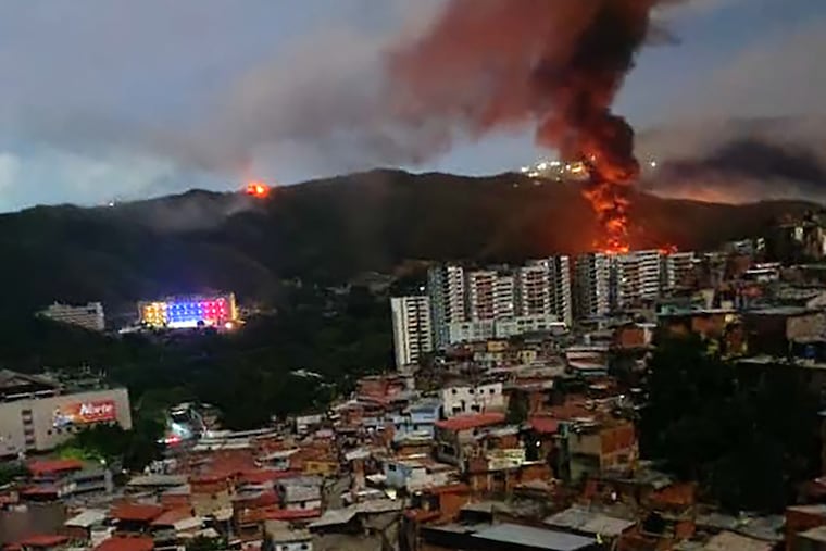 Fire at Fuerte Tiuna, Venezuela's largest military complex, is seen from a distance after a series of explosions in Caracas on January 3, 2026. The United States military was behind a series of strikes against the Venezuelan capital Caracas on Saturday, US media reported.