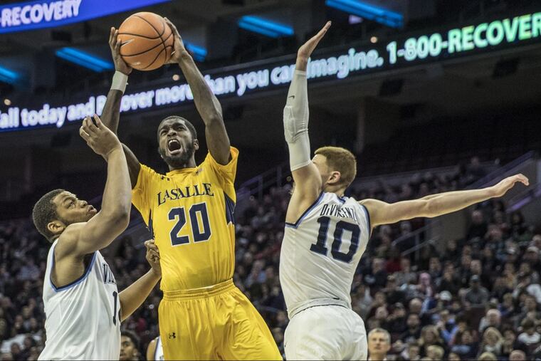 La salle’s 320, B.J. Johnson, center, tries to go in between the defense of Villanova’s #14, Omari Spellman, left, and #10, Donte DiVincenzo, right, in the second half of their game on Sunday December 10, 2017. Mens college basketball La Salle at Villanova at Wells Fargo Center on Sunday December 10, 2017.