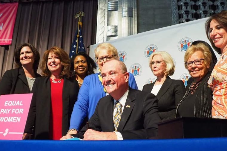 Gov. Murphy signs the Diane B. Allen Equal Pay Act into law, giving New Jersey the strongest equal pay law in the country. Immediately behind him are Allen, left, and activist Lilly Ledbetter.