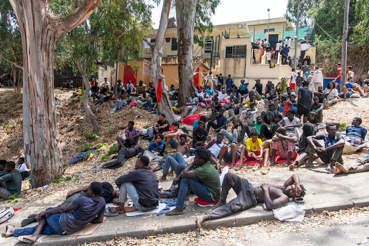 Migrants rest outside the Temporary Center for Immigrants (CETI) after crossing from Morocco into the Spanish enclave of Ceuta, Friday, July 31, 2026.