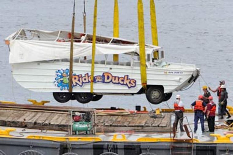 The Ride the Duck amphibious craft that was run over by a city-owned barge dangles above a salvage barge after being hoisted out of the Delaware River. (Clem Murray / Staff Photographer)