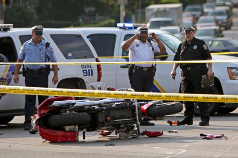 Accident investigators gather on Roosevelt Boulevard in Oxford Circle after a hit-and-run accident claimed the life of an off-duty Philadelphia Police Officer who was riding his motorcycle. (Joseph Kaczmarek / for the Inquirer and Daily News)